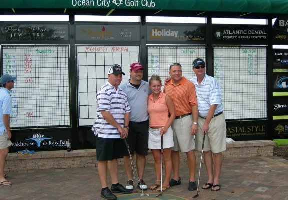 Golfers in Ocean City Maryland in front of golf score board 