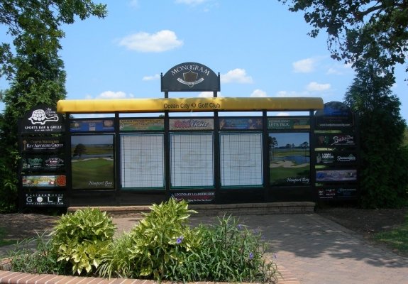 leader board on golf course with advertising